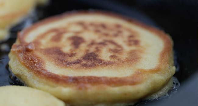 cooking a johnny cake in some butter in a skillet