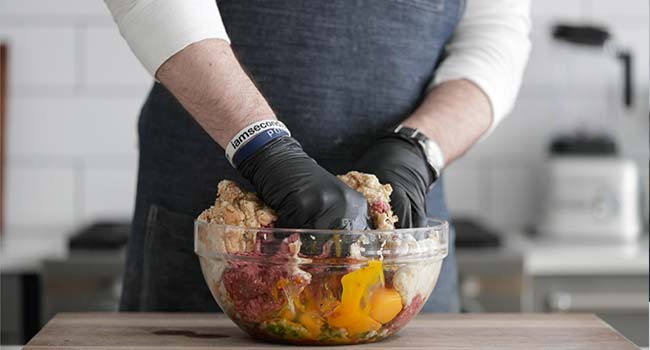 mixing together meatloaf ingredients in a bowl