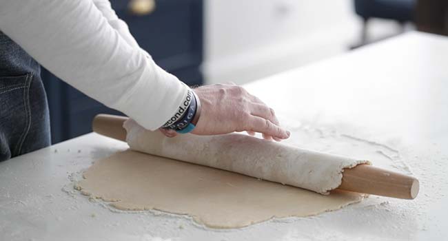 rolling pie dough around a rolling pin