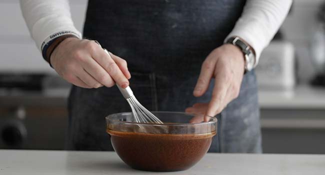 whisking molasses in a large bowl