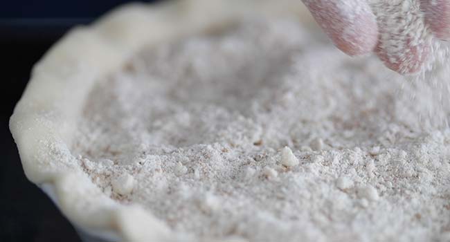 adding streusel to the top of the molasses filling in the pie