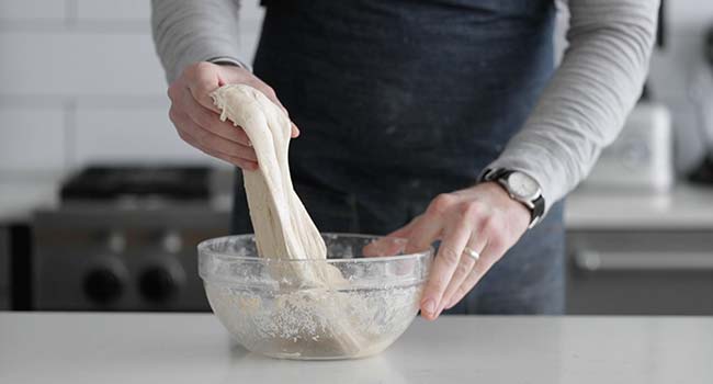 folding sourdough in a bowl