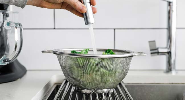 rinsing cut romaine lettuce in a sink
