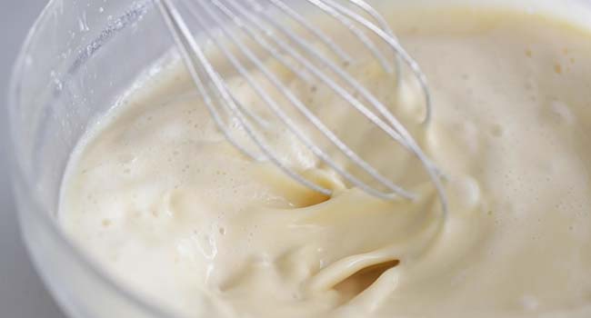 whisking together milk, eggs and flour in a bowl