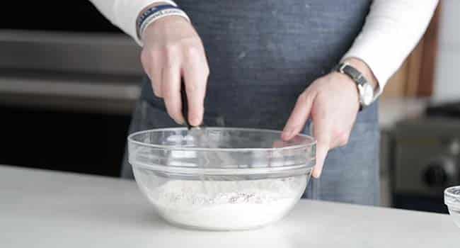 mixing together dry ingredients with a whisk in a bowl