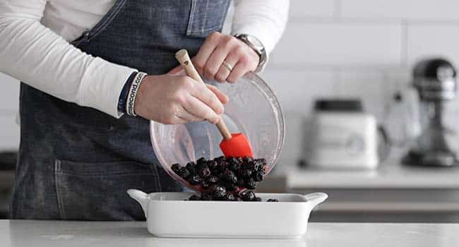 adding blackberries to a casserole dish