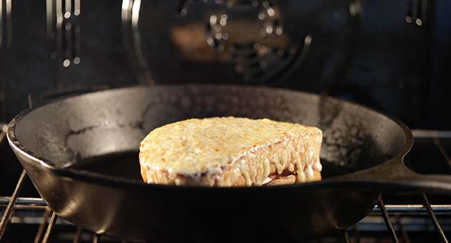 croque monsieur melting under the broiler in a pan