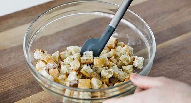 mixing cubed bread in a bowl