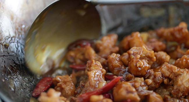 general tso's chicken in sauce in a wok