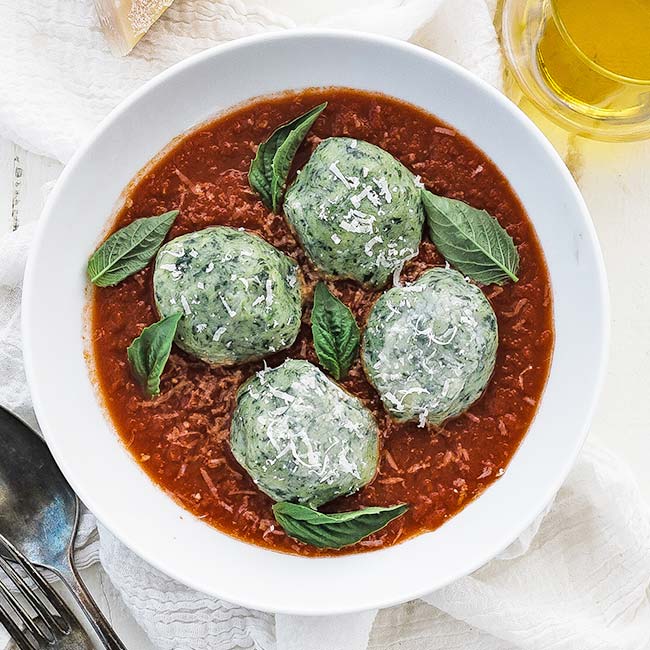 bowl of tomato sauce with spinach gnudi