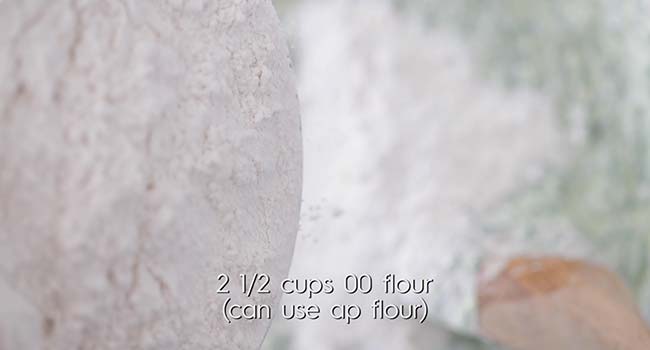 adding flour to a bowl of gnudi dough