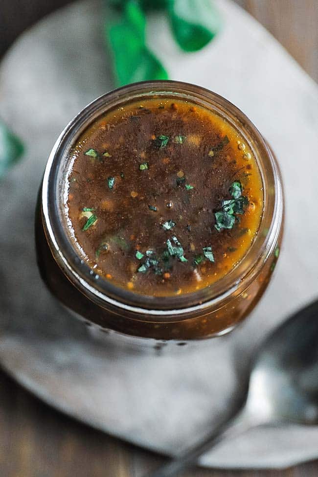 balsamic vinaigrette recipe in a jar with fresh chopped basil