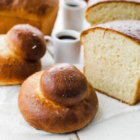 homemade brioche bun and a loaf of brioche sliced in half