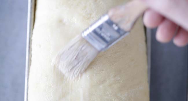 brushing brioche dough with an egg wash