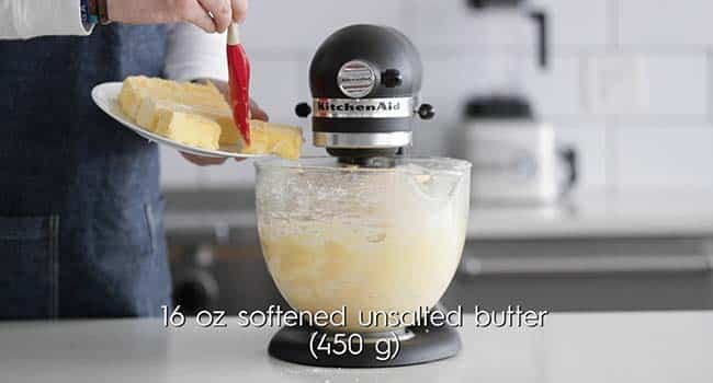 adding softened butter to a brioche dough mixing in a stand mixer