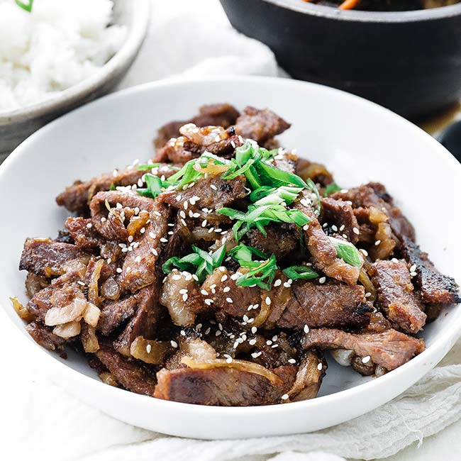 bowl of thinly sliced beef bulgogi with green onions