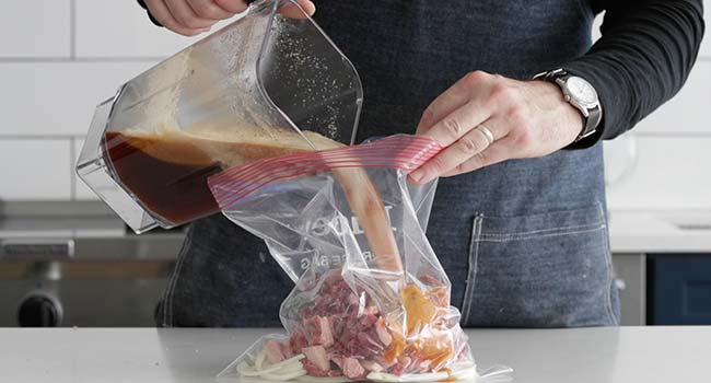 pouring a bulgogi marinade into a bag with onions and beef