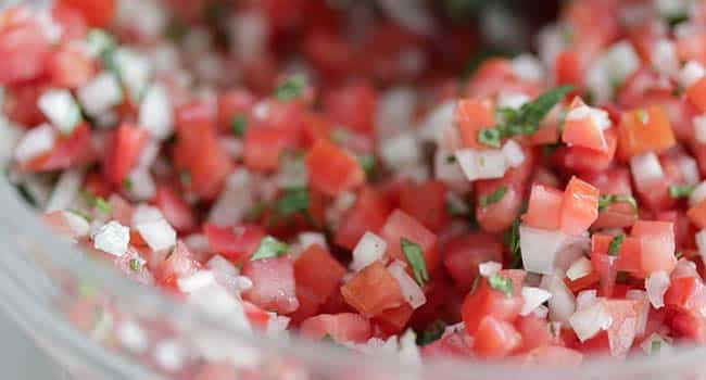 a bowl of tomato salsa with onions and cilantro