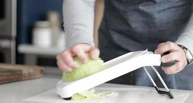slicing green cabbage on a mandolin
