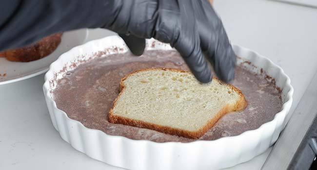 dipping brioche bread slice into batter