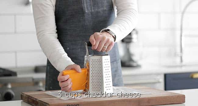 grating cheddar cheese on a cheese grater