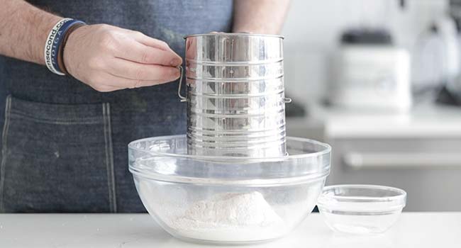 sifting together ingredients into a bowl