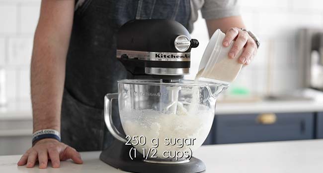 mixing ricotta in a stand mixer while adding in sugar