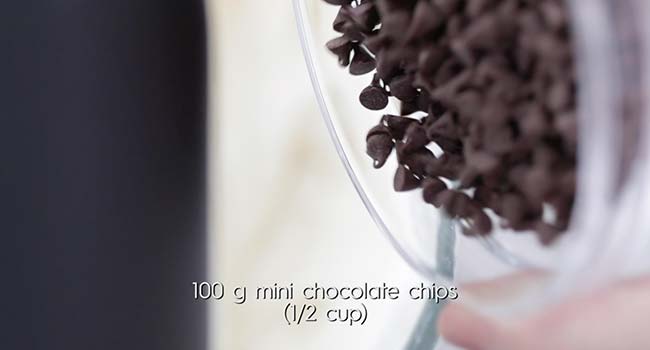 adding chocolate chips to a stand mixer