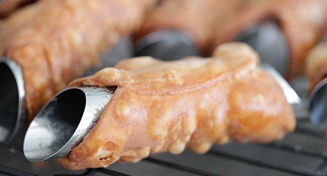 draining fried cannoli shells on a rack