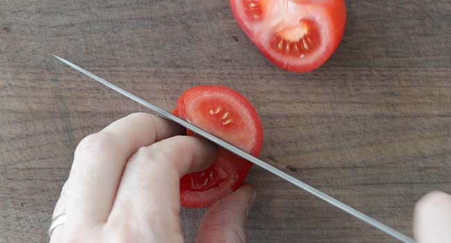 slicing tomatoes on a cutting board