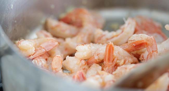 cooking shrimp in cooked garlic in a pot