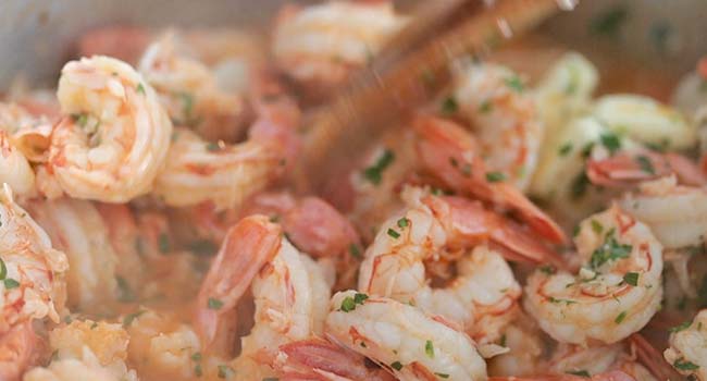 cooked shrimp with parsley and butter in a pot