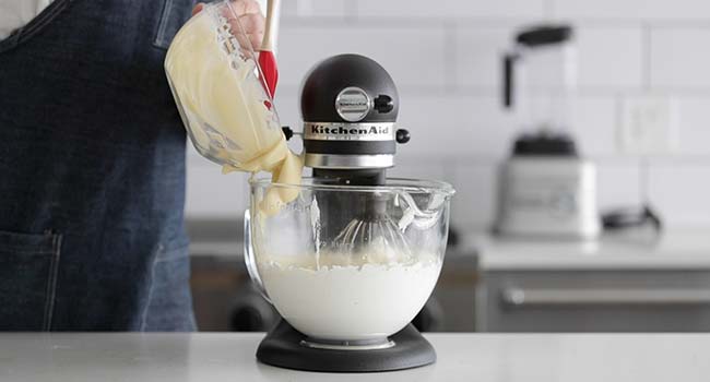 adding custard to meringue in a stand mixer