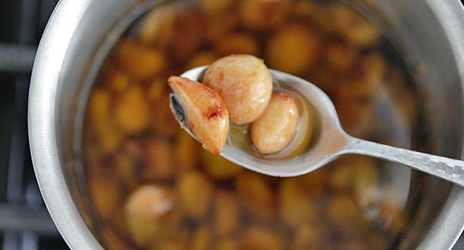 making roasted garlic confit in a pot of oil