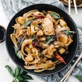 bowl of drunken noodles with chicken and basil