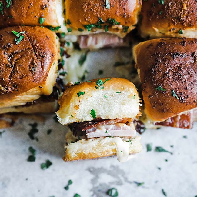 sweet rolls with ham and cheese on a sheet tray