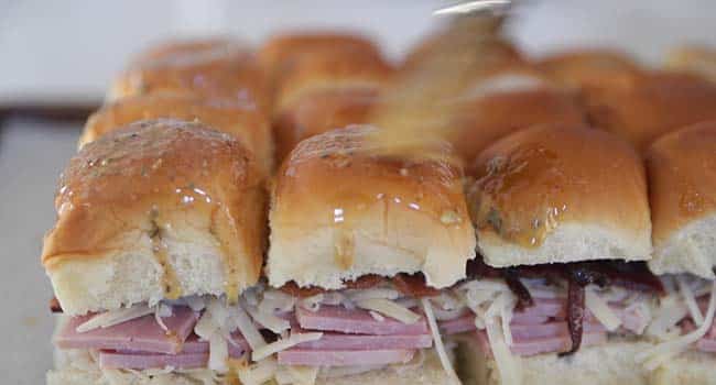 brushing the tops of buns with herb butter