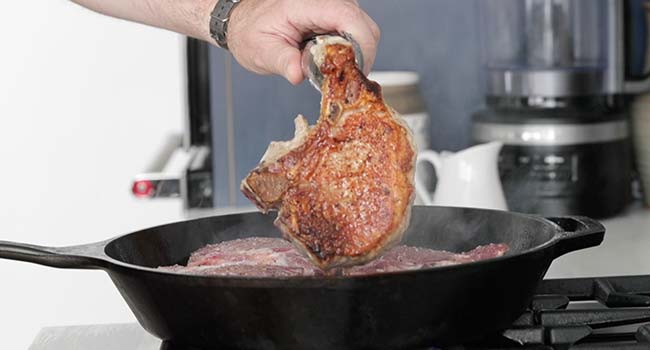 cooking bone in pork chops in a pan