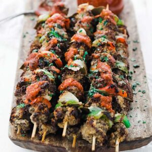 spiedini beef kebabs with sauce on a cutting board