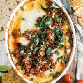 homemade queso dip with chips and tomatoes