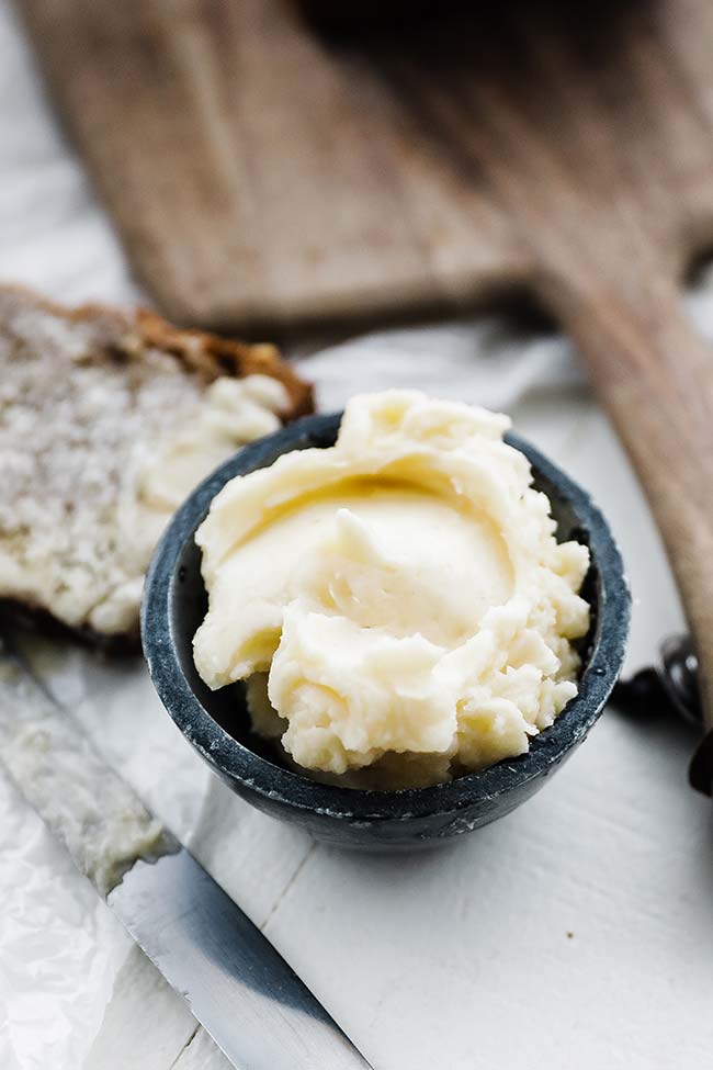 bowl of honey butter with slice of bread