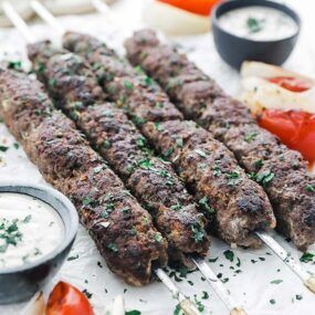 beef kebabs on parchment paper with vegetables