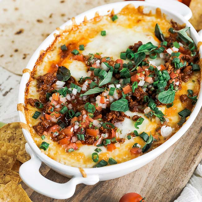 casserole dish of queso dip with tomatoes and chorizo