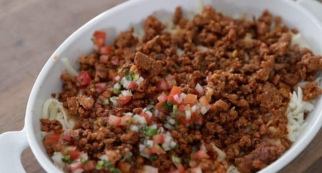 layering chorizo and pico de gallo in a casserole dish