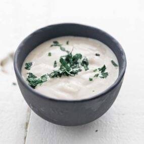 jar of homemade tahini sauce with parsley