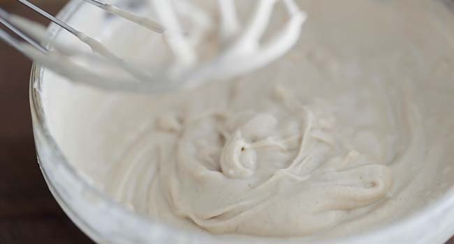 whisking together tahini sauce in a bowl