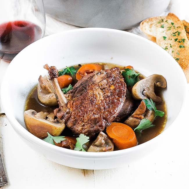 bowl of coq au vin with carrots and mushrooms