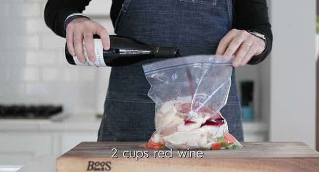 marinating chicken in a plastic bag with wine and vegetables
