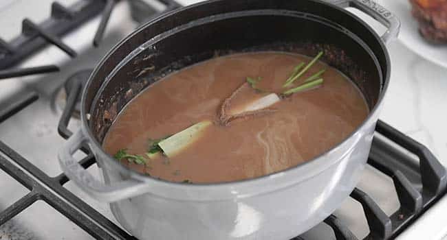 wine, broth, and herbs in a pot