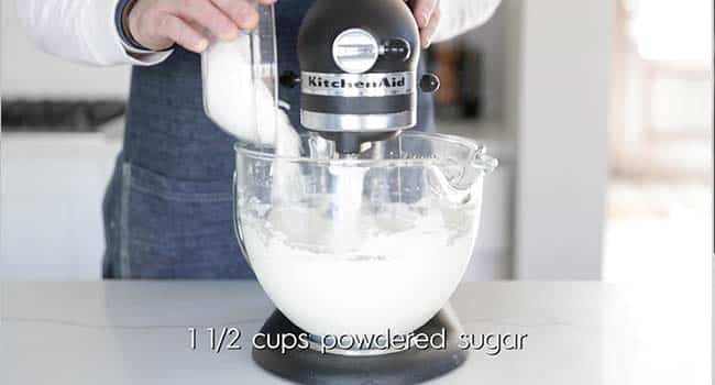 adding powdered sugar to a stand mixer